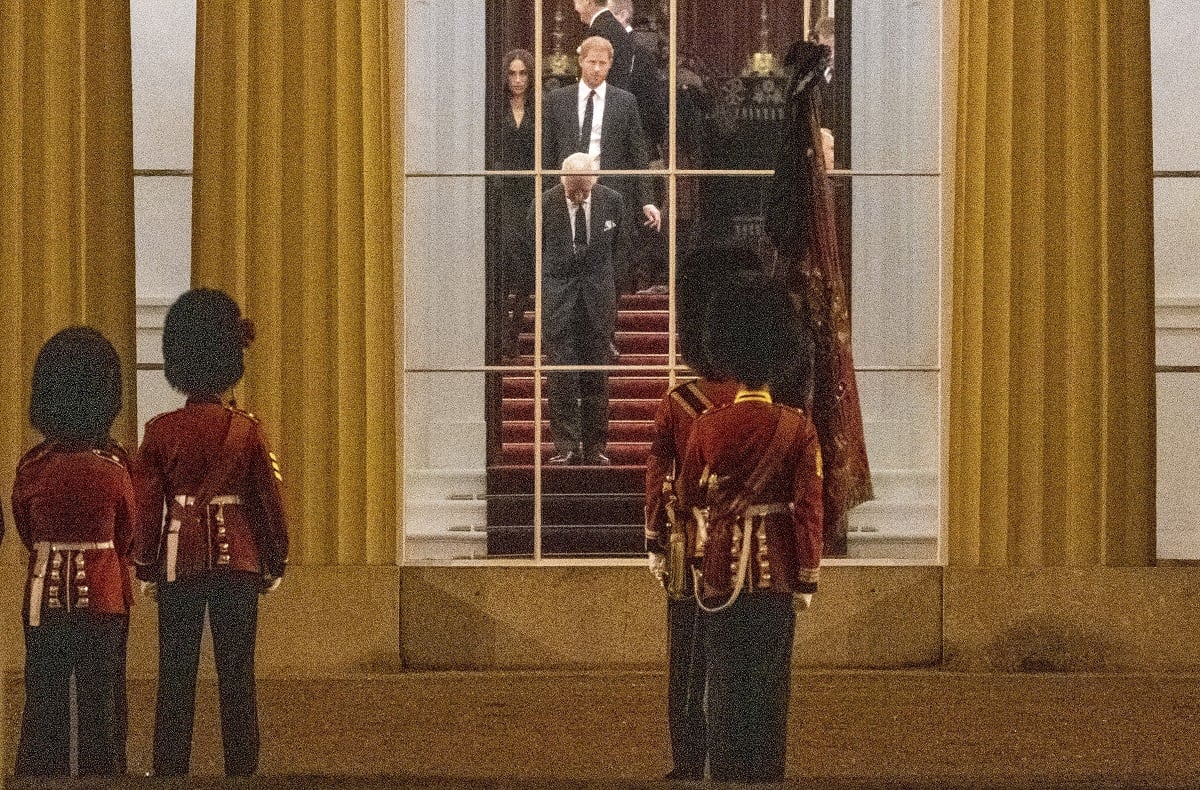 King Charles III, who reportedly "shunned" Prince Harry, and Meghan Markle, inside Buckingham Palace as they wait for the royal hearse carrying Queen Elizabeth II's coffin to arrive