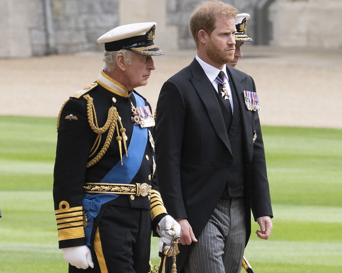 King Charles, who according to an expert probably didn't 'purposefully' wait to inform Prince Harry of Queen Elizabeth's death until after a public announcement, walks with Prince Harry during Queen Elizabeth's funeral