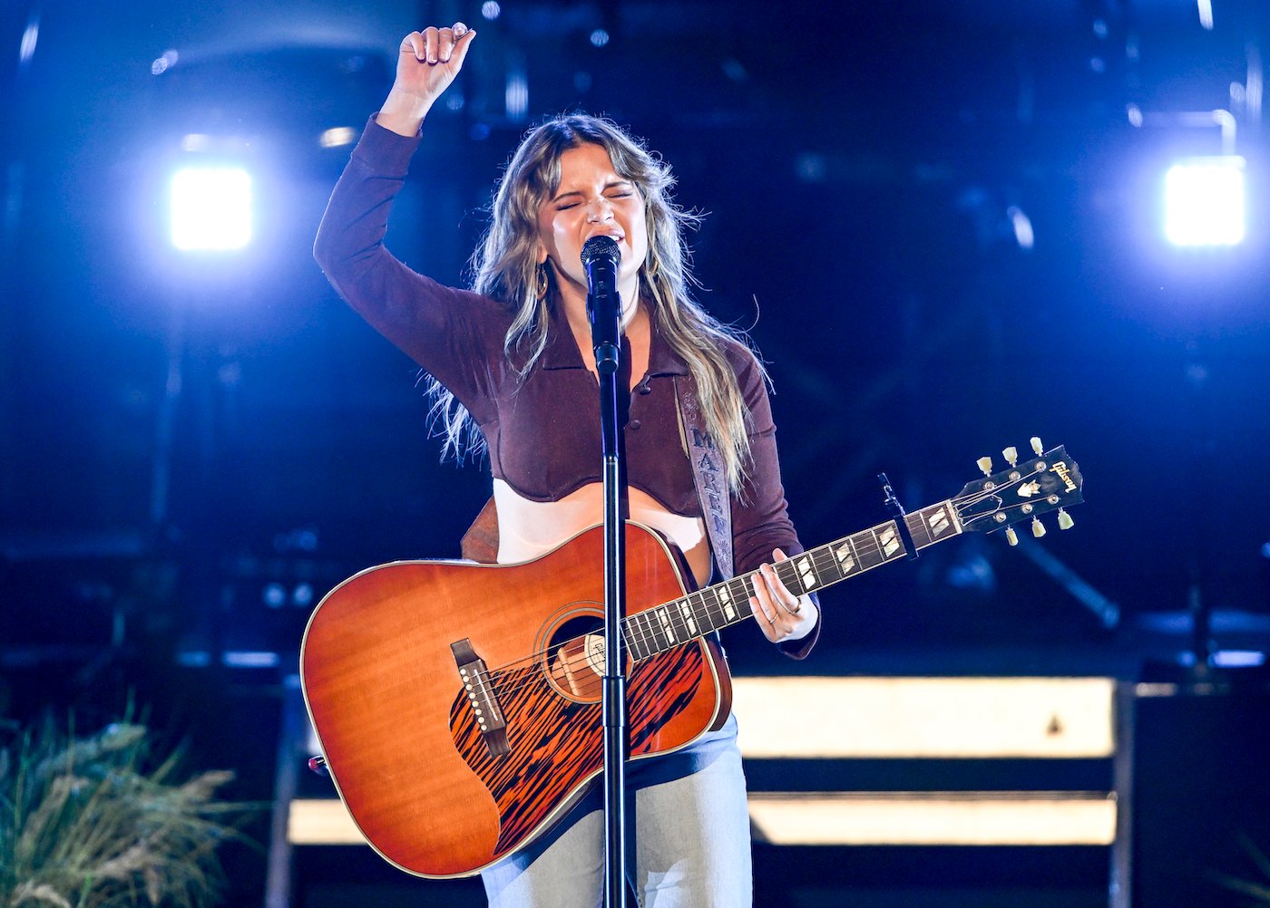 Maren Morris, who was in a feud with Jason and Brittany Aldean, playing guitar and singing on stage.