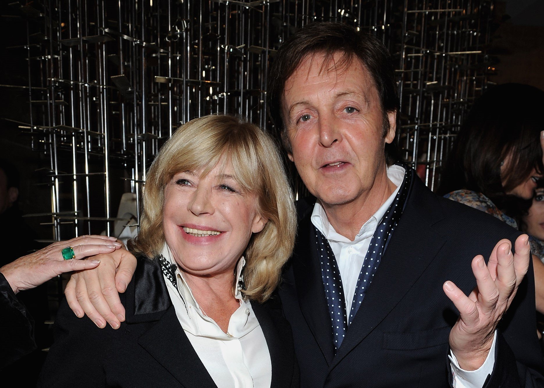 Paul McCartney stands with his arm around Marianne Faithfull's shoulders.