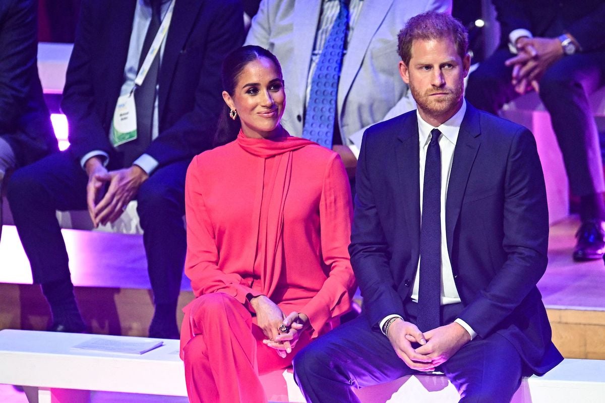 Meghan Markle and Prince Harry, who released a portrait from the One Young World opening ceremony taken by Misan Harriman, sit next to each other at the 2022 One Young World opening ceremony in September 2022