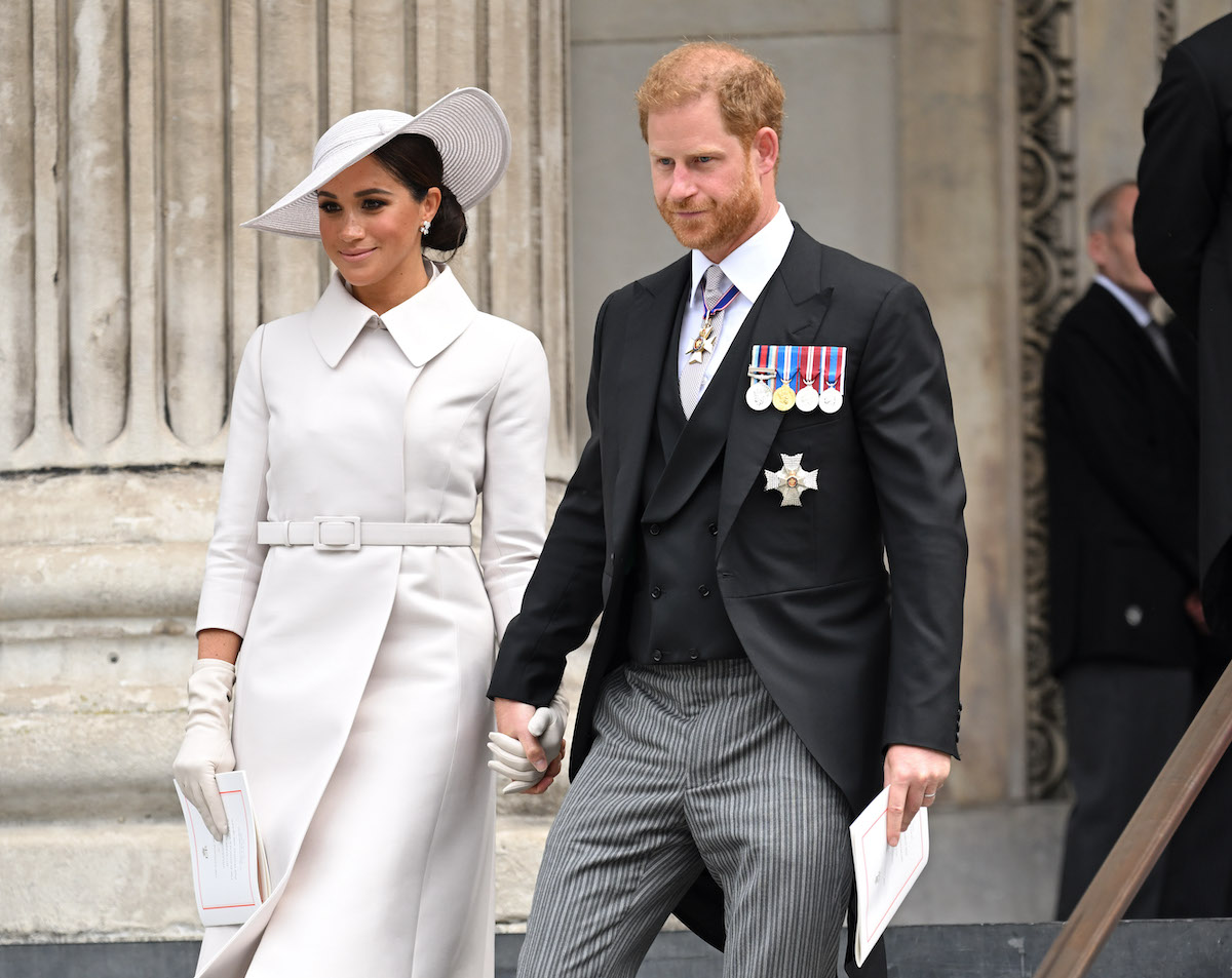 Meghan Markle and Prince Harry, who left the royal family in 2020, hold hands outside St Paul's Cathedral.