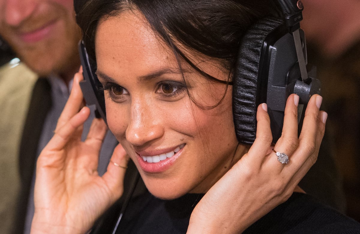 Meghan Markle, whose 'Archetypes' intro from the Oct. 11 episode of the podcast which a body language expert called 'intriguing,' listens to headphones