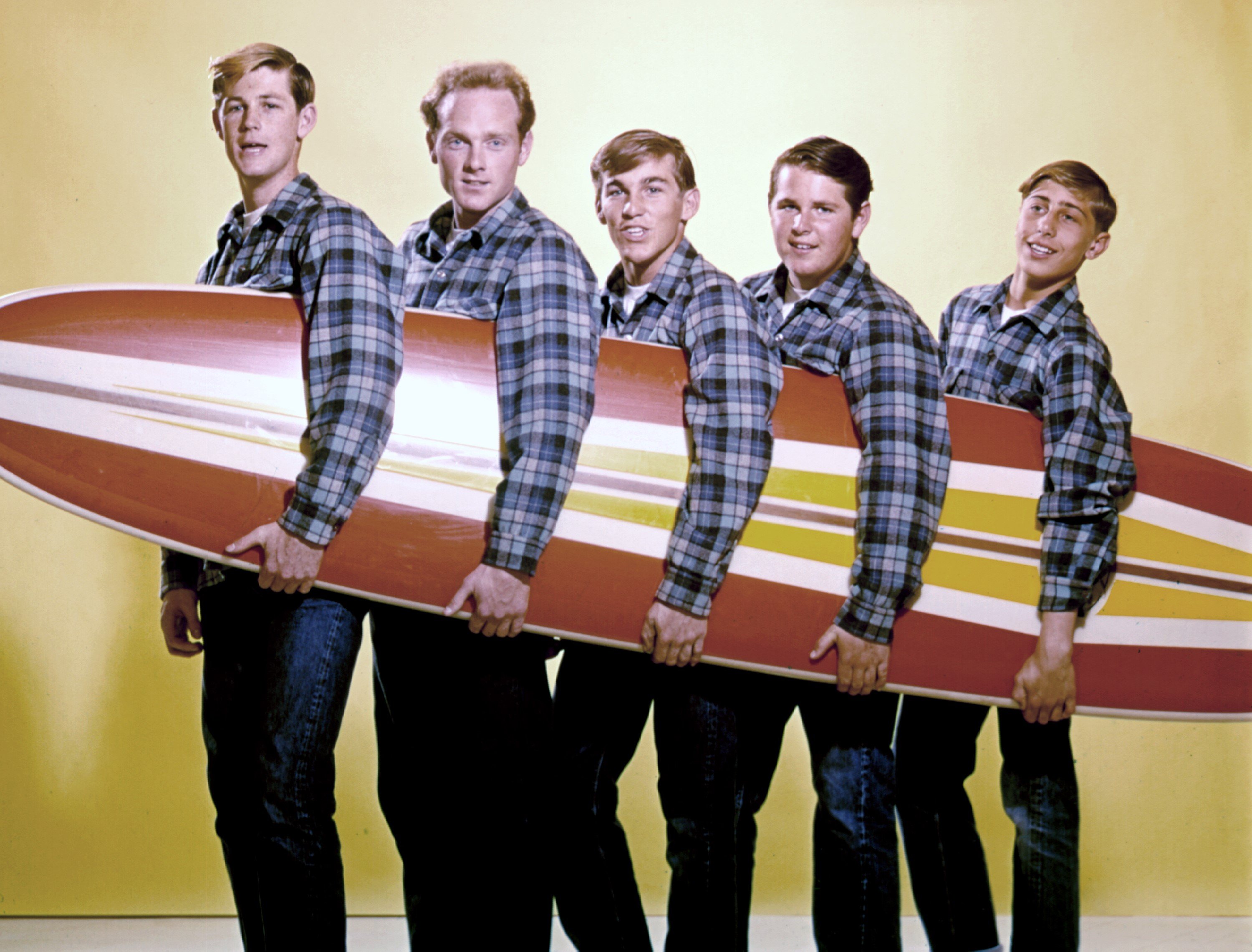 The Beach Boys holding a surf board during the "California Girls" era