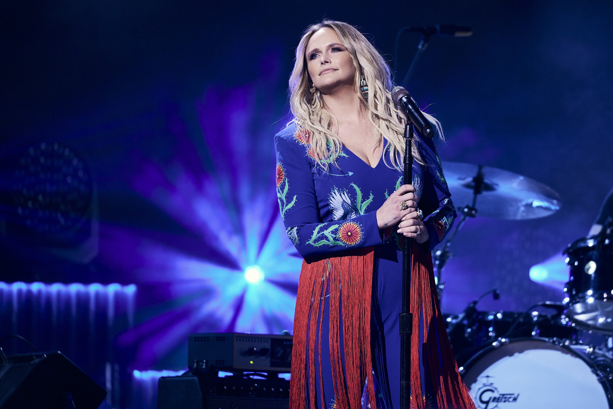 Miranda Lambert stands on stage holding a microphone stand