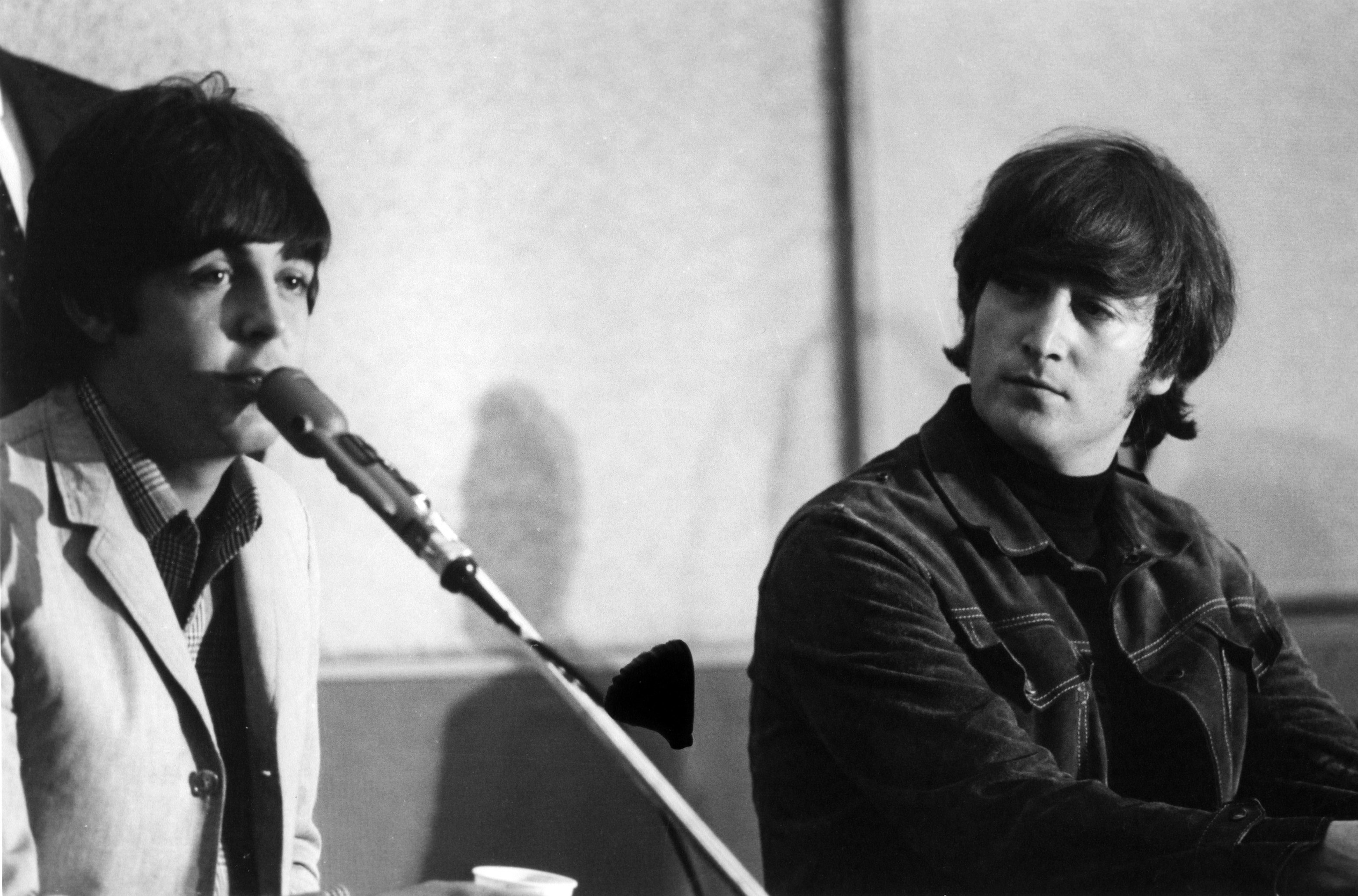 Paul McCartney and John Lennon of The Beatles at a press conference for their album 'Help!'
