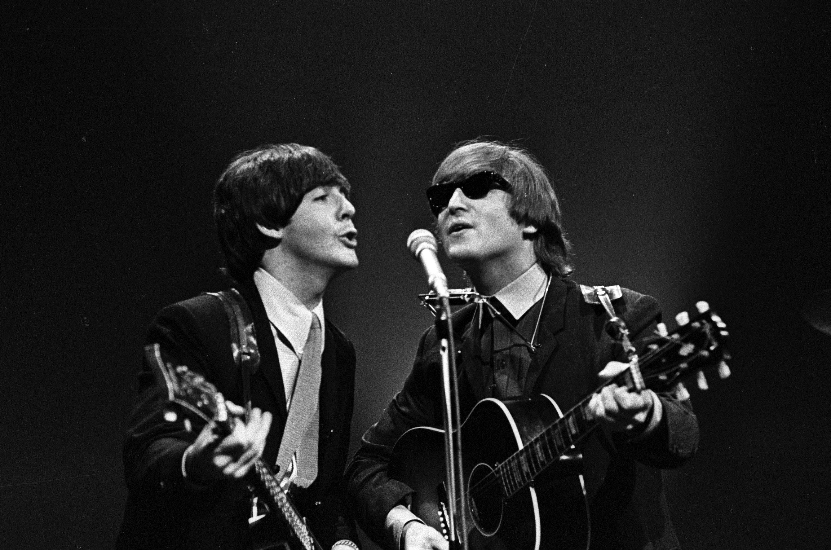 Paul McCartney and John Lennon of The Beatles perform