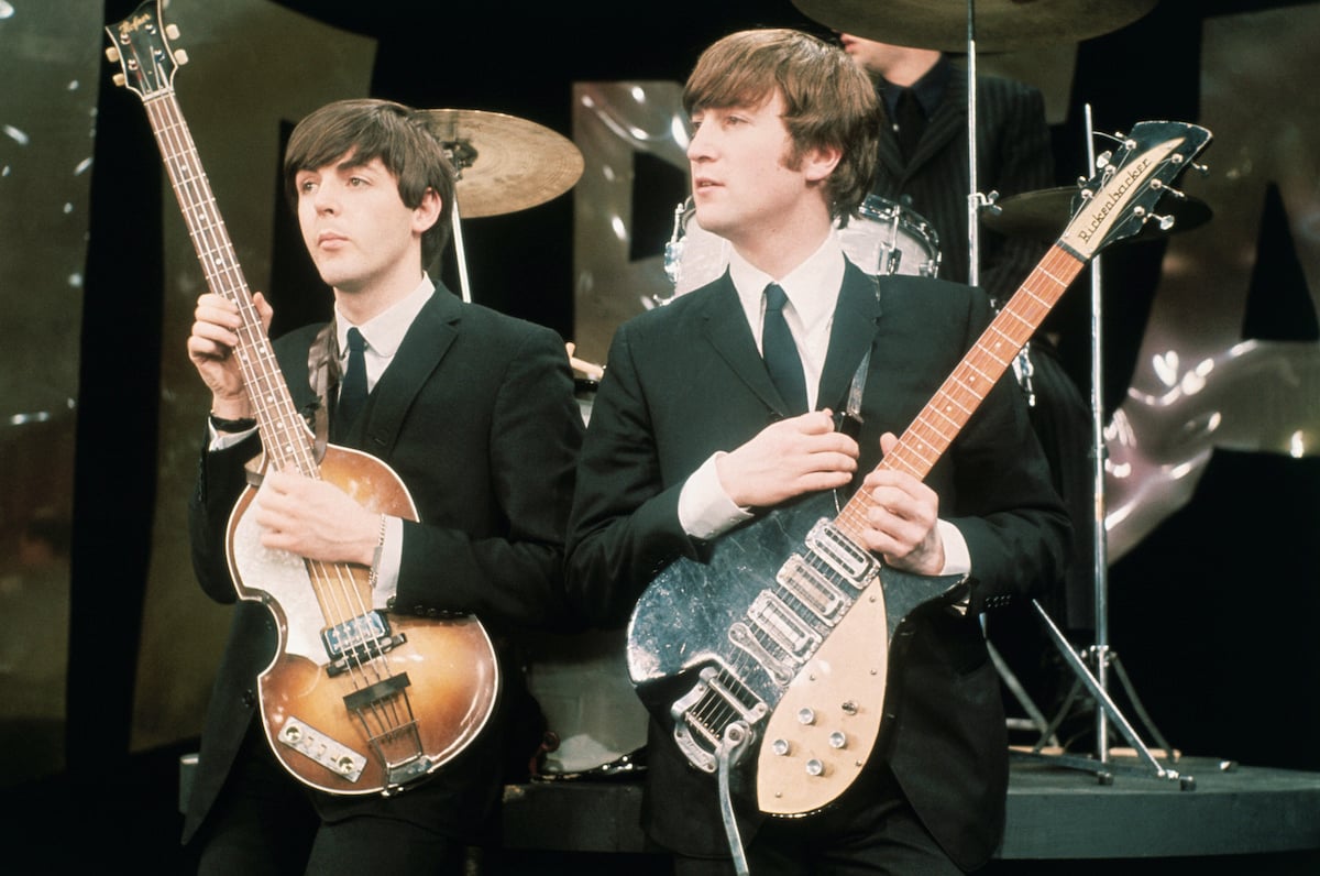 Paul McCartney and John Lennon holding their guitars