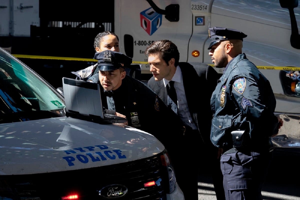 'The Calling': Juliana Canfield as Janine Harris, and Jeff Wilbusch as Avraham Avraham looking at a computer at a crime scene