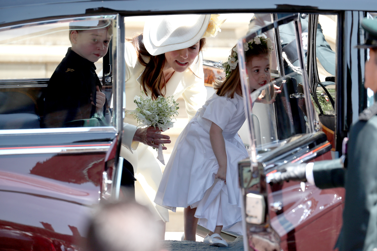 Prince George, Kate Middleton, and Princess Charlotte arrive at Prince Harry and Meghan Markle's wedding, which came before a 2018 story Meghan Markle allegedly made Kate Middleton cry which was a story it would've been 'very dangerous' for the palace to comment on publicly according to author Valentine Low