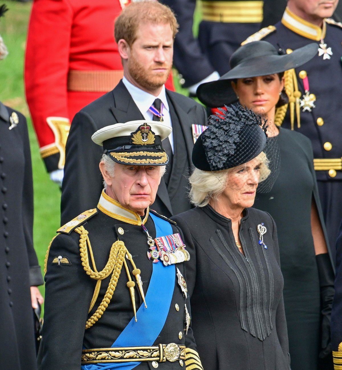 Prince Harry, Meghan Markle, King Charles III, and Camilla Parker Bowles observe Queen Elizabeth II's coffin as it is transferred from the gun carriage to the hearse