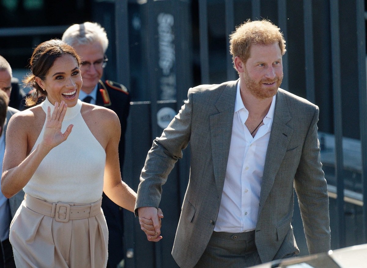 Prince Harry and Meghan Markle walk to a car after taking a boat trip on the Rhine in Germany