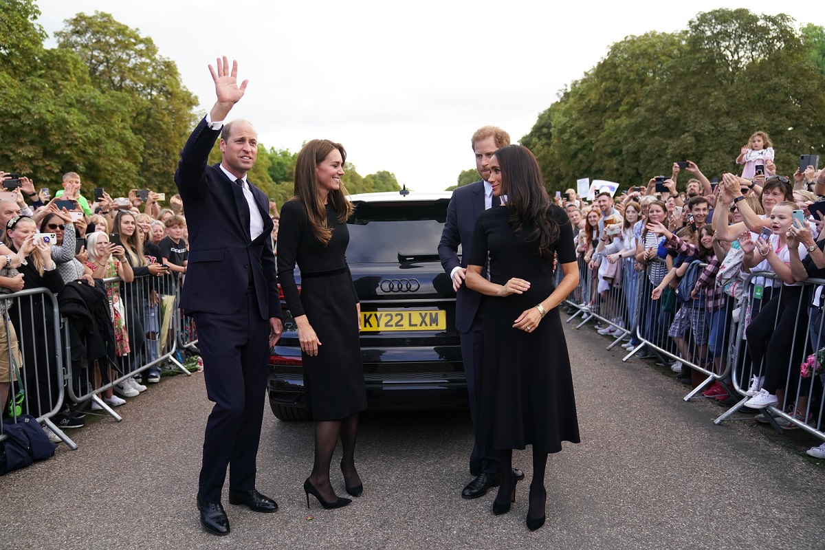 Prince William, Kate Middleton, Prince Harry, and Meghan Markle smile and wave after greeting members of the public on the Long Walk at Windsor Castle