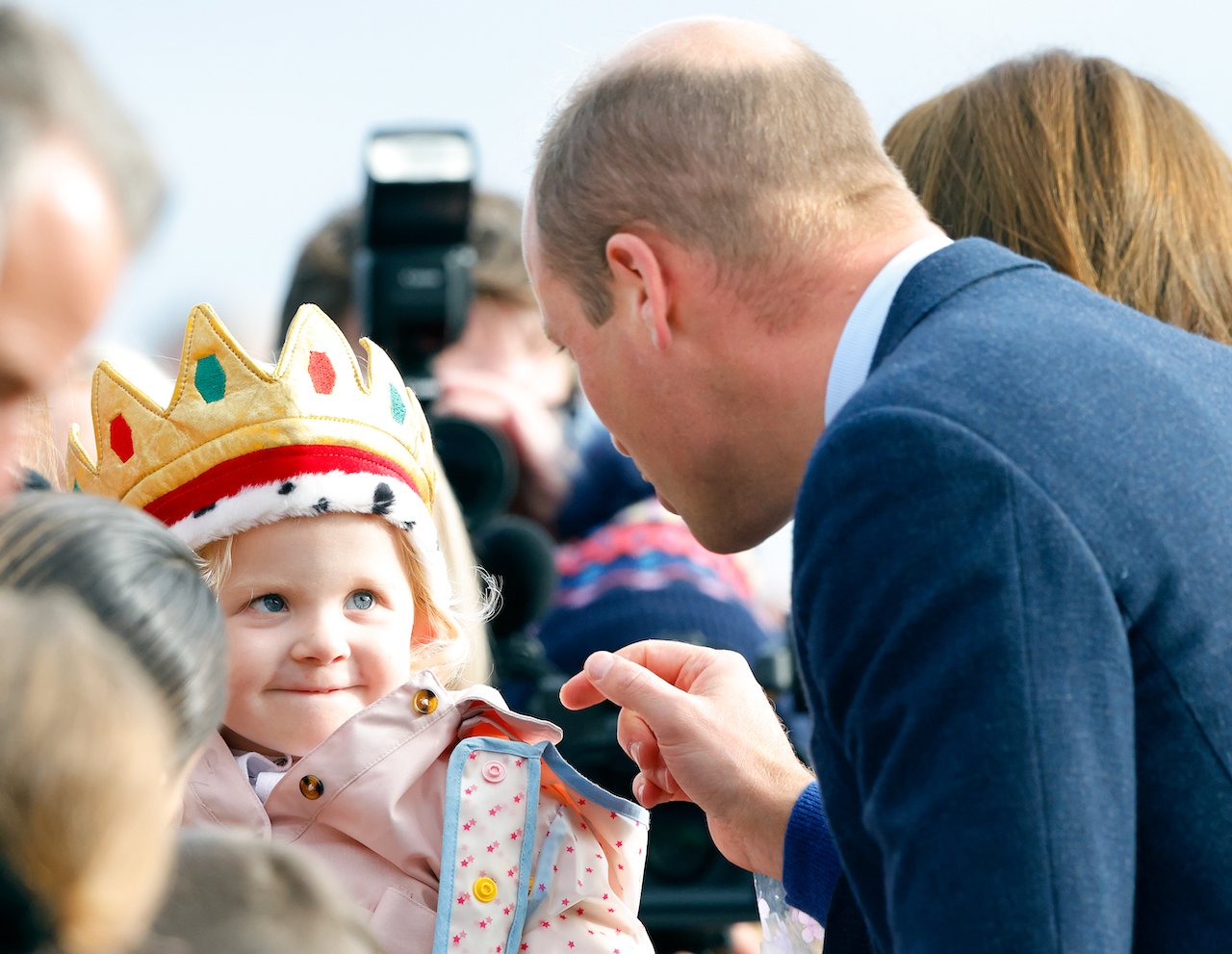 Prince William, Prince of Wales meets a young, crown-wearing, member of the public during a walkabout on October 6, 2022.