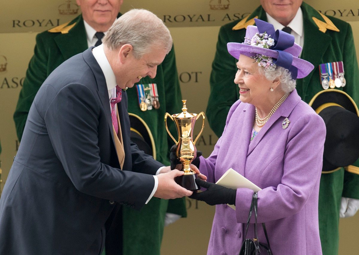 Queen Elizabeth II is presented The Gold Cup by Prince Andrew after her horse won