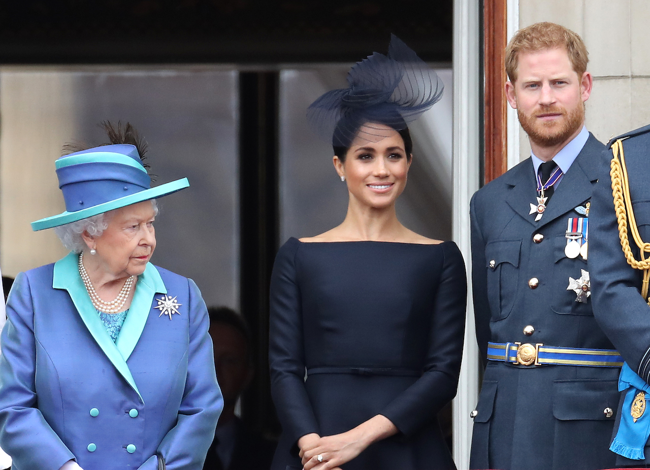 Queen Elizabeth II, Prince Harry, Duke of Sussex and Meghan, Duchess of Sussex on the balcony of Buckingham Palace as the Royal family attend events to mark the Centenary of the RAF on July 10, 2018 in London, England. Queen Elizabeth was