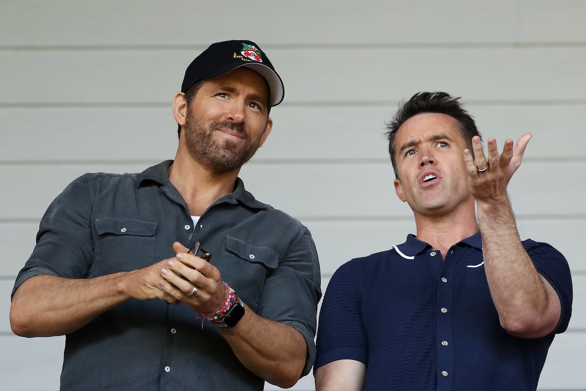 Owners of Wrexham Football Club, Ryan Reynolds and Rob McElhenney, cheer during a game