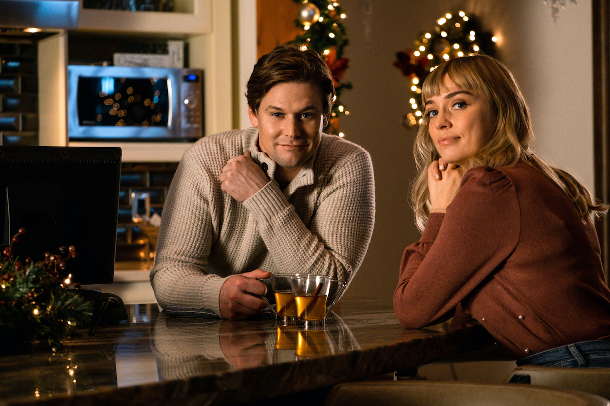 Man and woman sitting at table in front of Christmas decoration in 'Serving Up the Holidays'