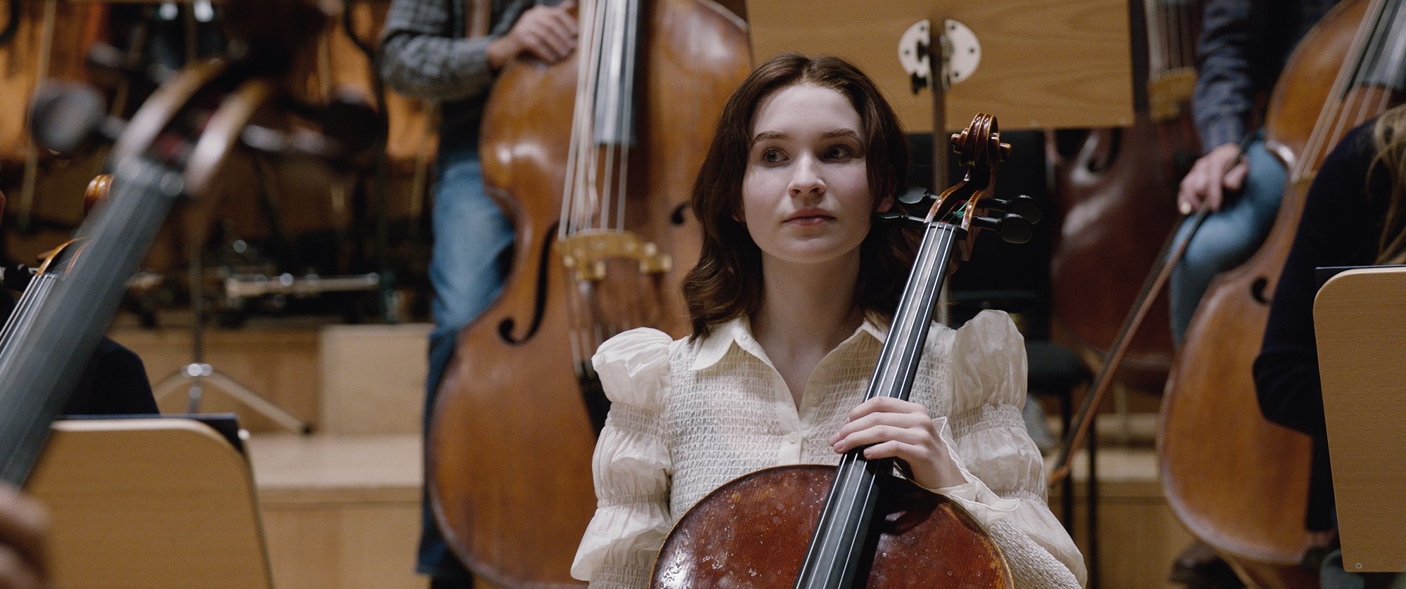 'TÁR' Sophie Kauer as Olga Metkina looking uncertain, holding her cello