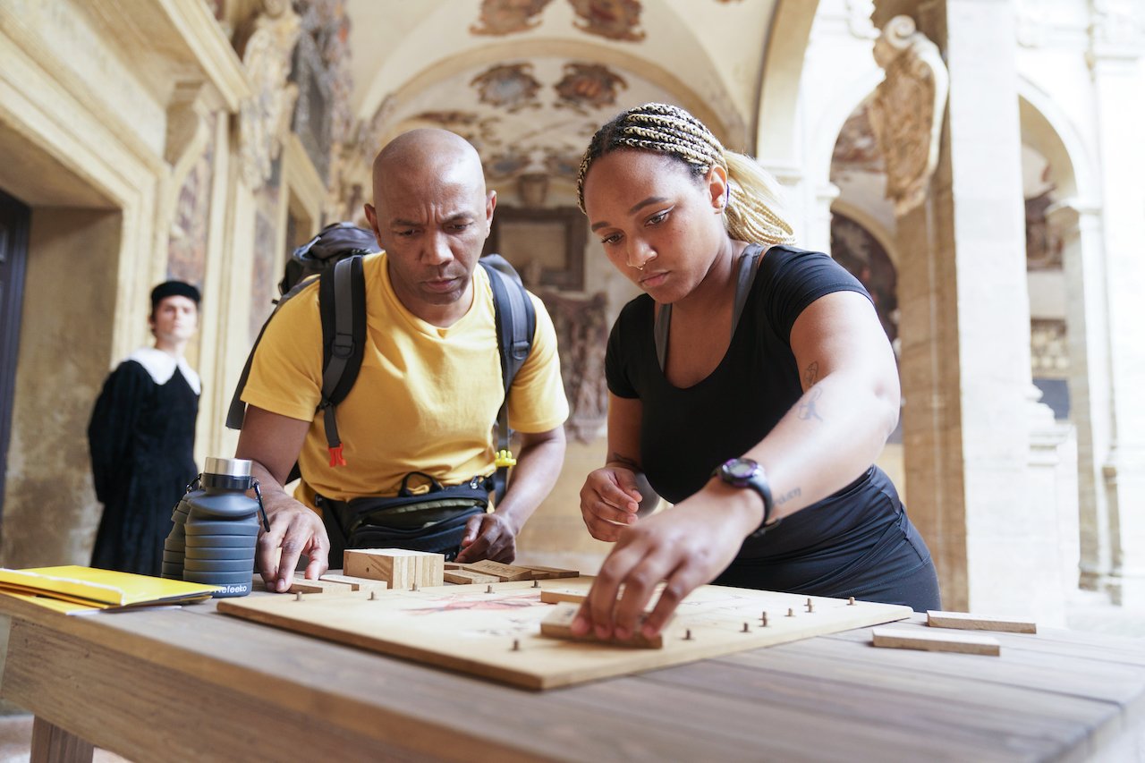 Linton Atkinson and Sharik Atkinson work together over a board in Italy on 'The Amazing Race'.
