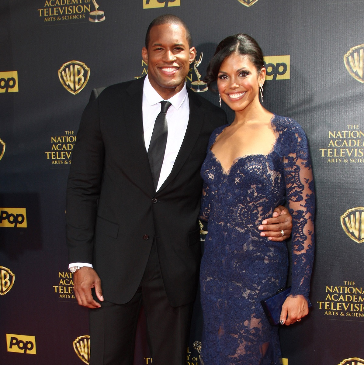 'The Bold and the Beautiful' star Lawrence Saint-Victor in a tuxedo and Karla Mosley in a blue dress; pose together for a photo.