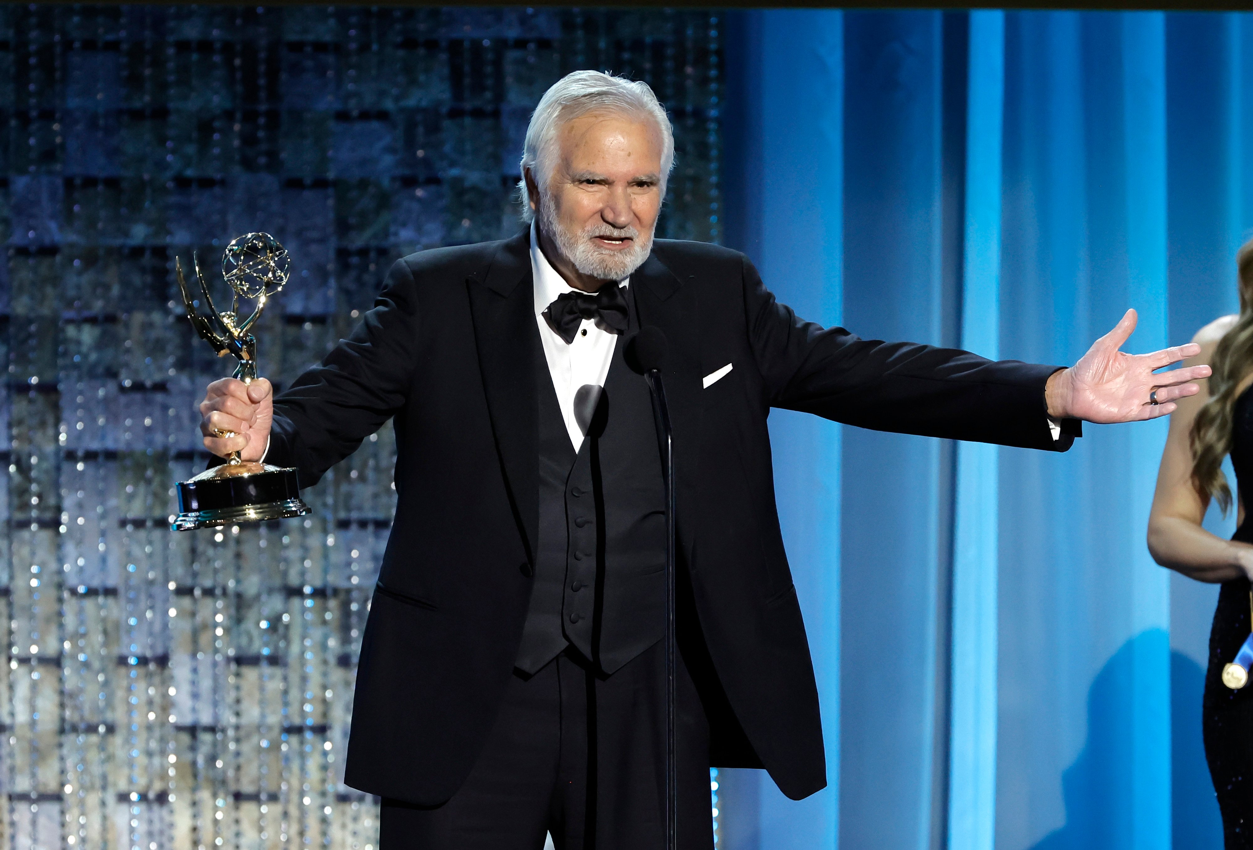 'The Bold and the Beautiful' star John McCook dressed in a tuxedo, celebrates his 2022 Daytime Emmy win onstage.