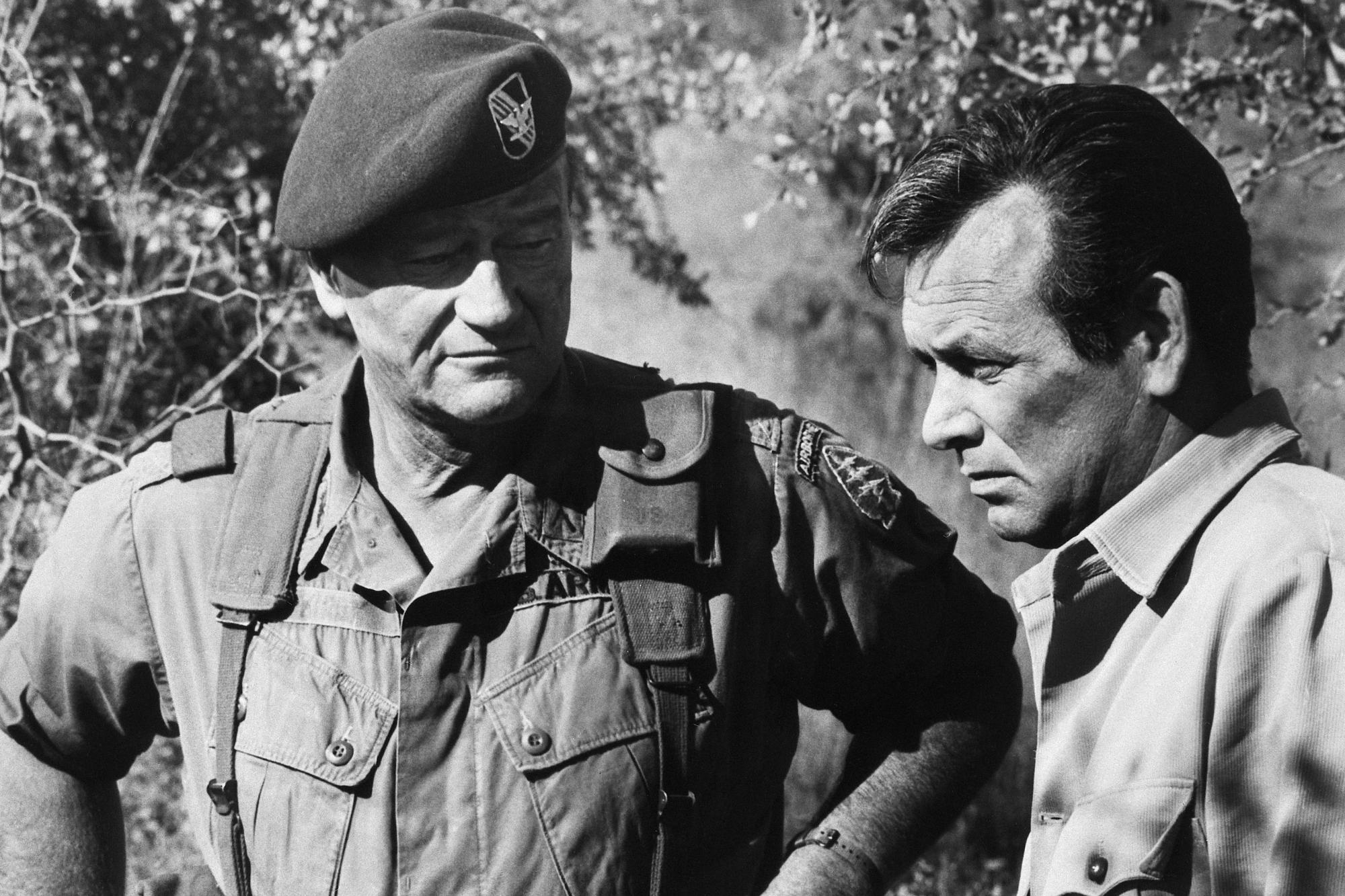 'The Green Berets' John Wayne as Col. Mike Kirby and David Janssen as George Beckworth in a black-and-white photo. Wayne is looking at Janssen, who is looking off.