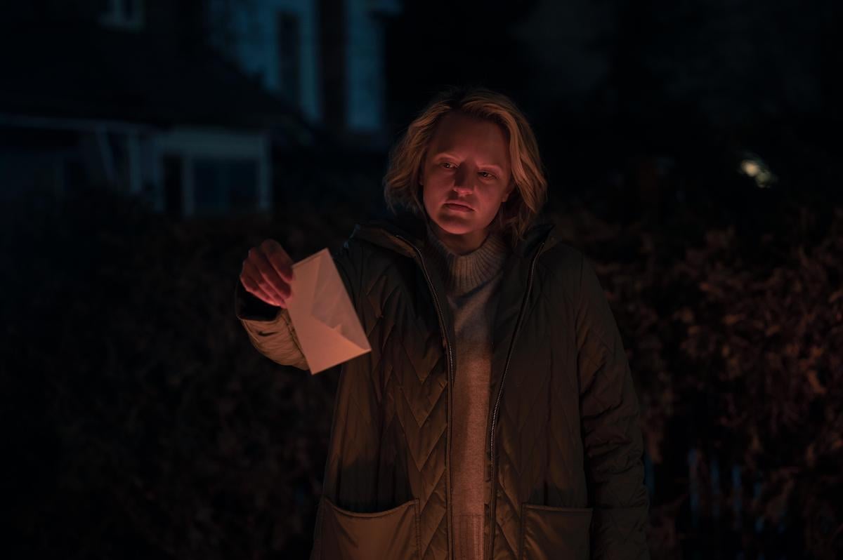 'The Handmaid's Tale' star Elisabeth Moss as June Osborne holding an envelope over a fire