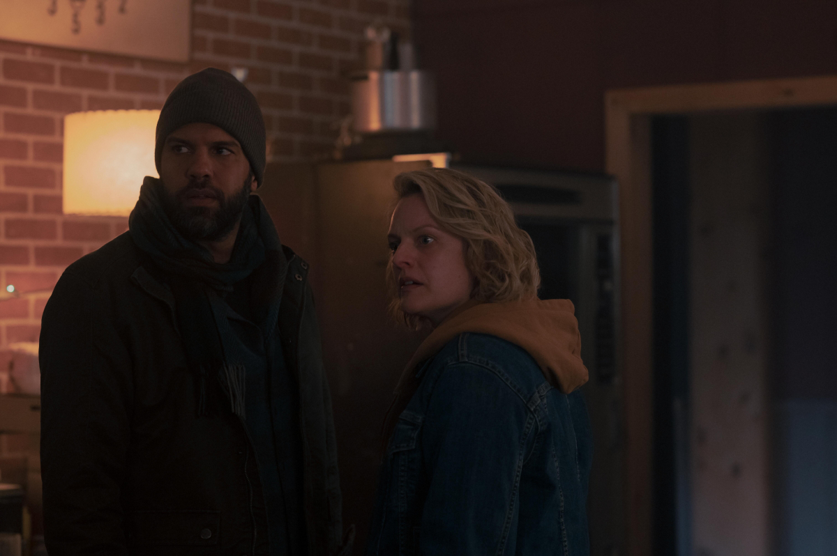 O-T Fagbenle as Luke and Elisabeth Moss as June in The Handmaid's Tale Season 5. Luke wears a coat and hat. June wears a hoodie and jacket.