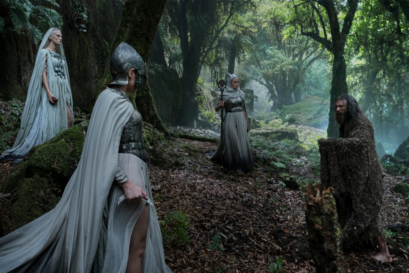 Daniel Weyman as The Stranger fighting the three White Cloaks in 'The Rings of Power' finale for our article about season 1's ending. They're surrounded by trees.