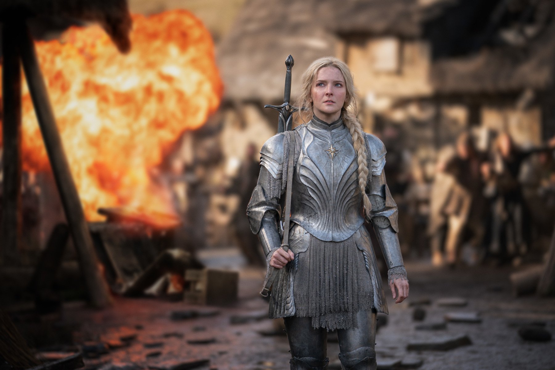 Morfydd Clark as Galadriel in 'The Rings of Power' for our article about a possible season 2 release date. She's wearing armor and walking away from a fire.