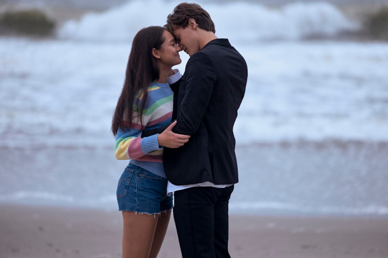 Belly (Lola Tung) and Conrad (Christopher Briney) kiss on the beach in 'The Summer I Turned Pretty' Season 1. 