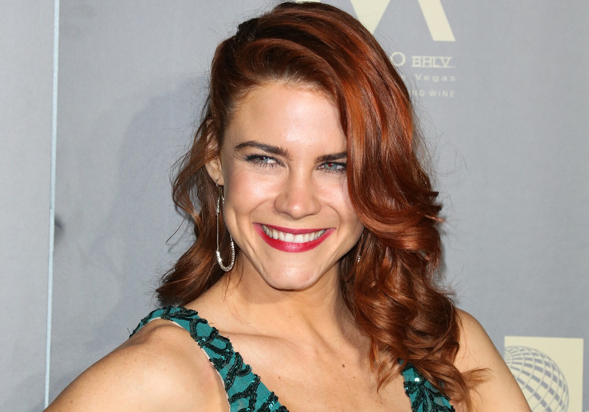 'The Young and the Restless' star Courtney Hope wearing a green dress and smiling for a photo.