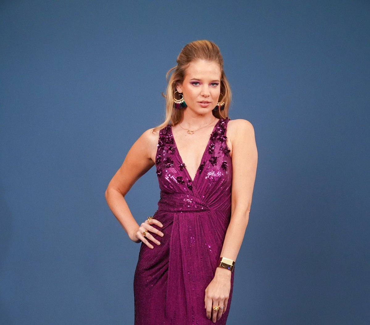 'The Young and the Restless' star Allison Lanier in a purple dress and posing in front of a blue backdrop.