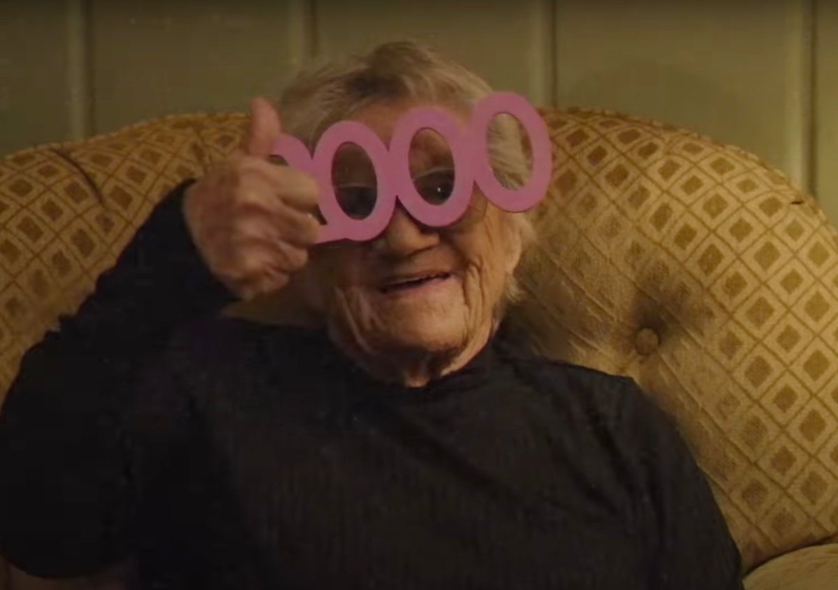 A grandma smiles and gives a thumbs up in the V/H/S/99 trailer