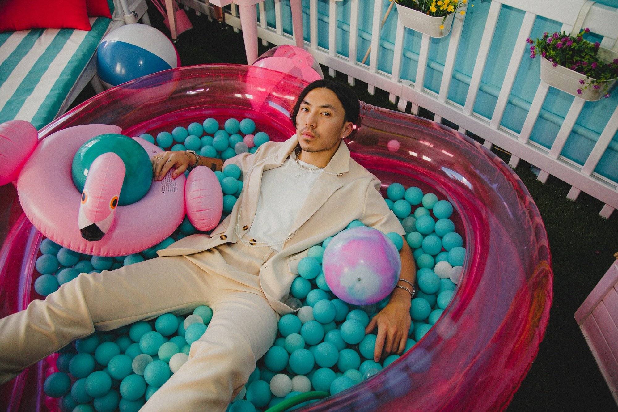 A promotional photo of VeeAlwaysHere sitting in a heart-shaped ball pit