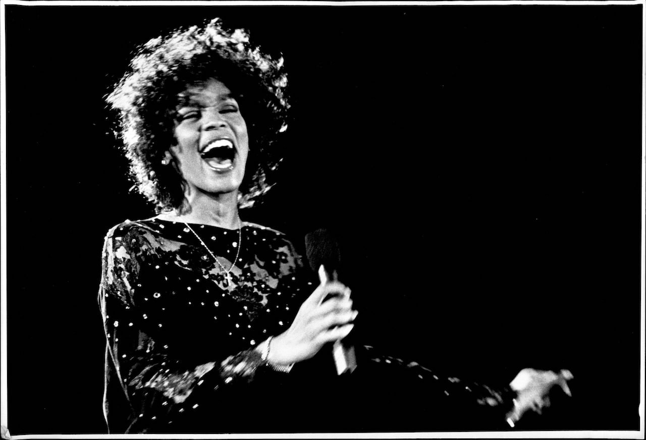 Whitney Houston sings on stage; Houston shot her 'So Emotional' music video in a small town