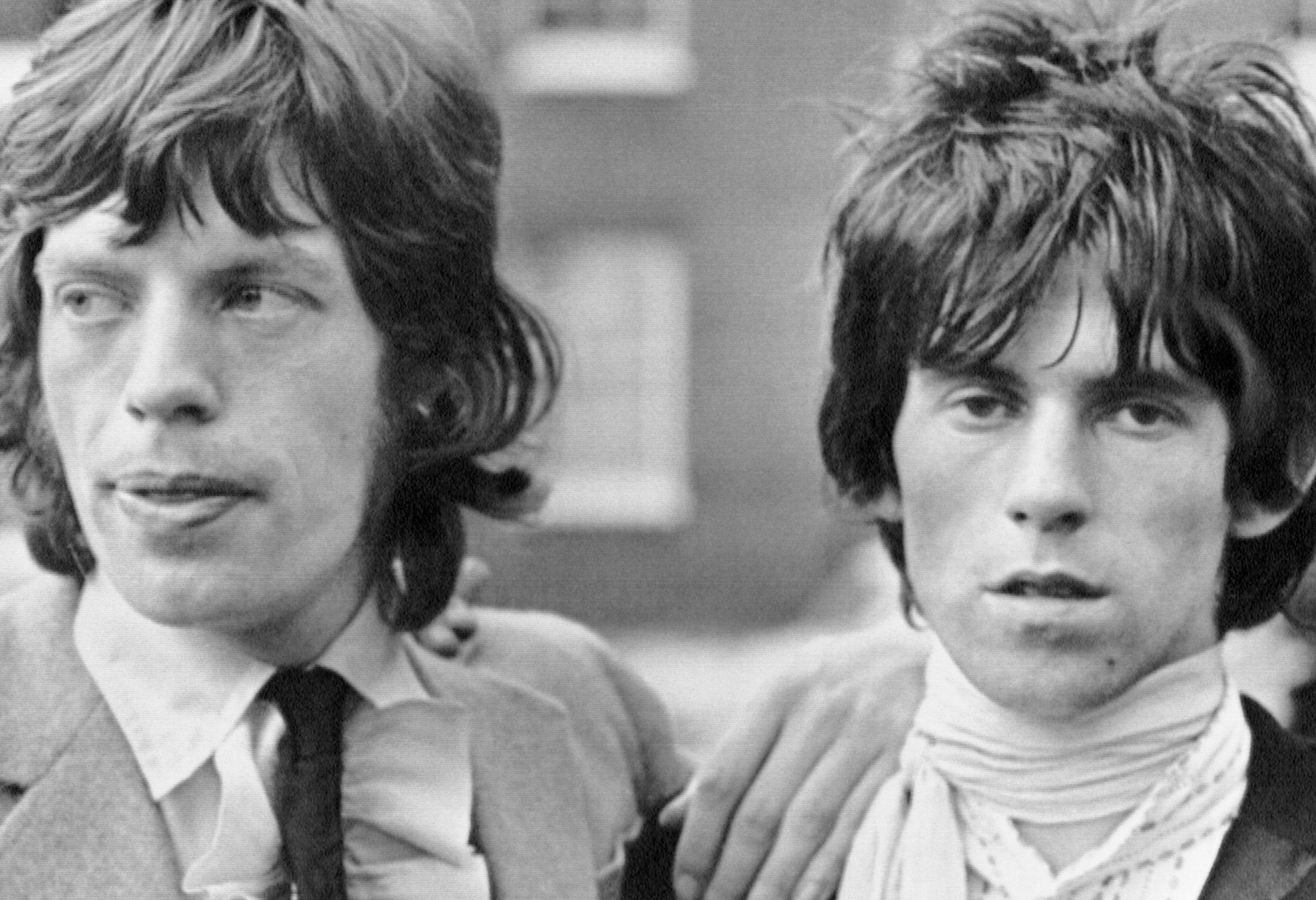 The Rolling Stones' Mick Jagger with his and on Keith Richards' shoulder