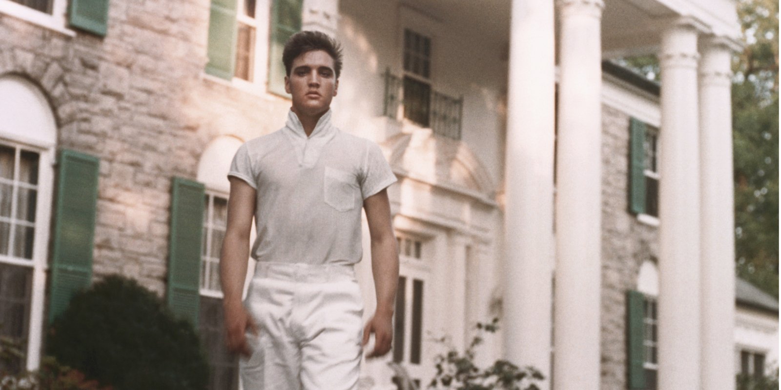 Elvis Presley poses outside of Graceland in Memphis, TN.