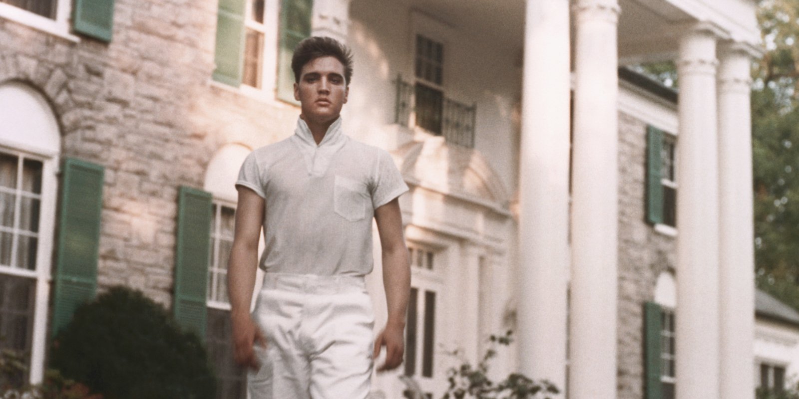 Elvis Presley walks in front of his Graceland home in Memphis, Tennessee.