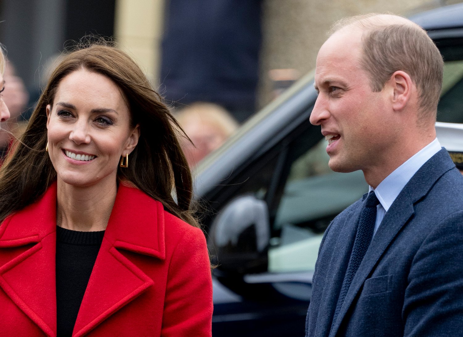 Kate Middleton wears a red coat and Prince William wears a suit and toes with the couple's body language revealing confidence