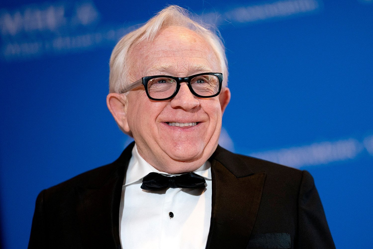 Leslie Jordan, the beloved actor and comedian, has died. In this picture, he smiles while wearing a tuxedo.