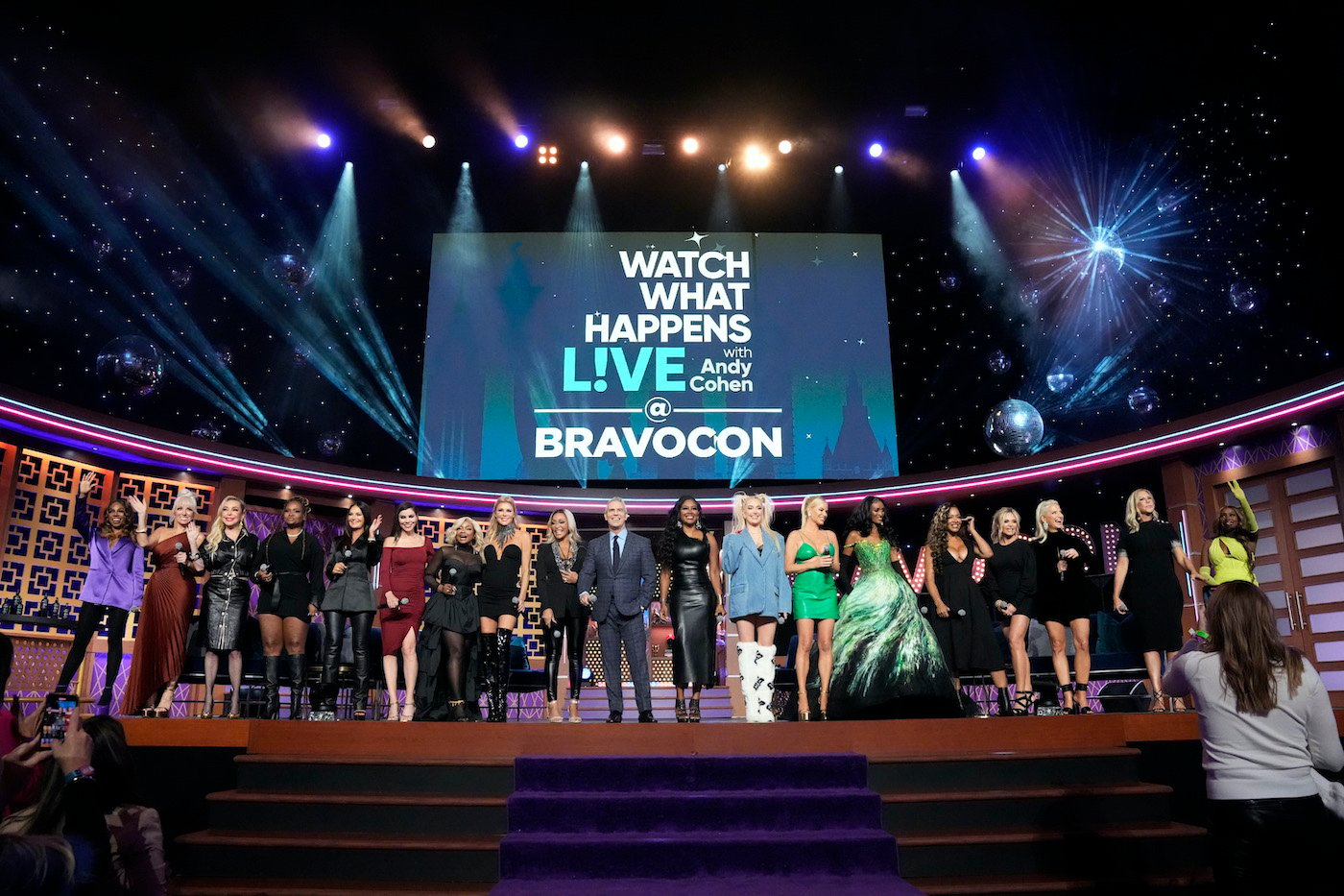 Andy Cohen stands in front of a lineup of Bravo talent as the reveal the new 2023 shows