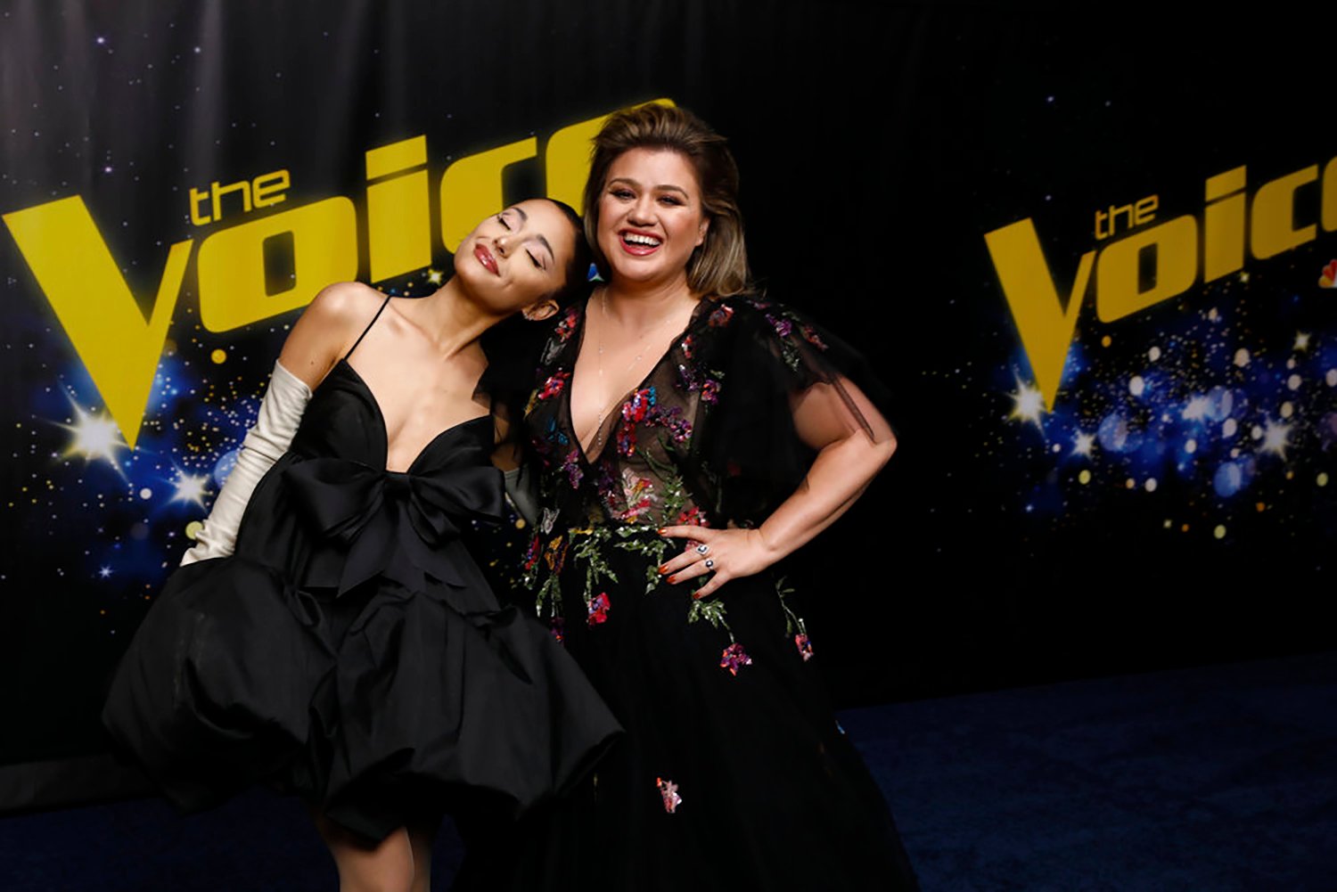 Ariana Grande and Kelly Clarkson, two of the highest paid judges on The Voice, pose together on the show on 2021