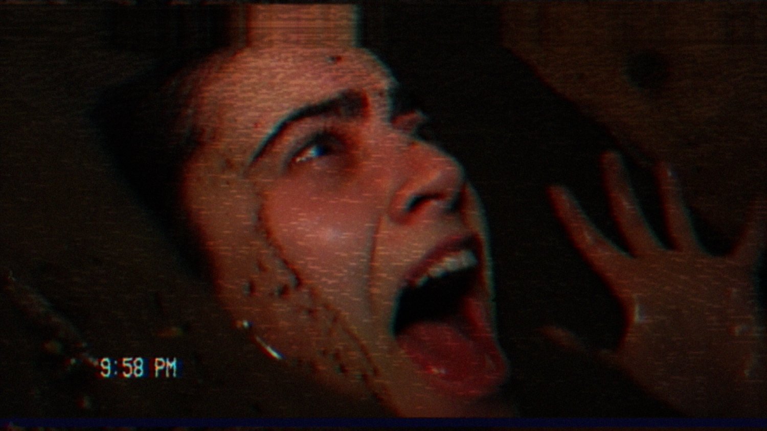 A young woman screams with blood on her face in a shot from the Shudder horror film 'V/H/S/99'