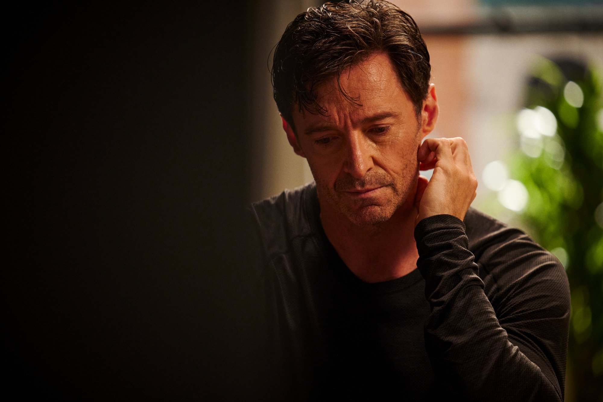 ‘The Son’ Hugh Jackman as Peter looking down with a sad look on his face. He's resting his hand on the back of his neck.