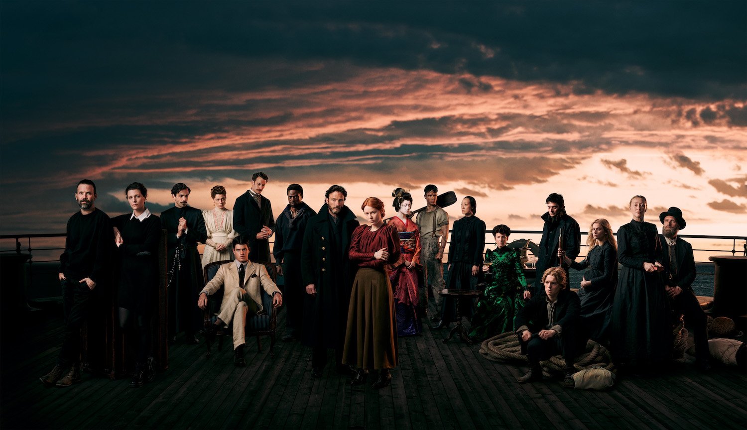 In '1899' the ships' names have ties to Greek mythology. In this production still, the entire cast stands on the deck of one of the ships while the sun sets behind them.