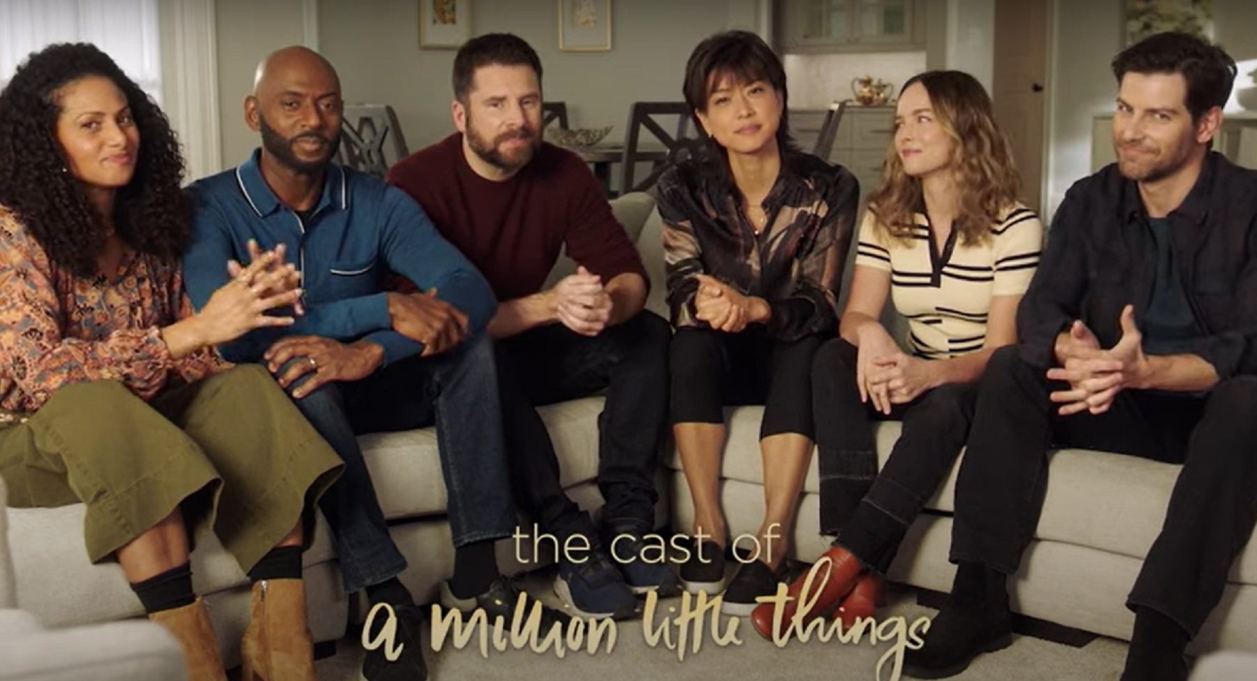 'A Million Little Things' Season 5 cast members David Giuntoli, Romany Malco, Allison Miller, James Roday Rodriguez, Christina Moses, and Grace Park sitting together on a couch