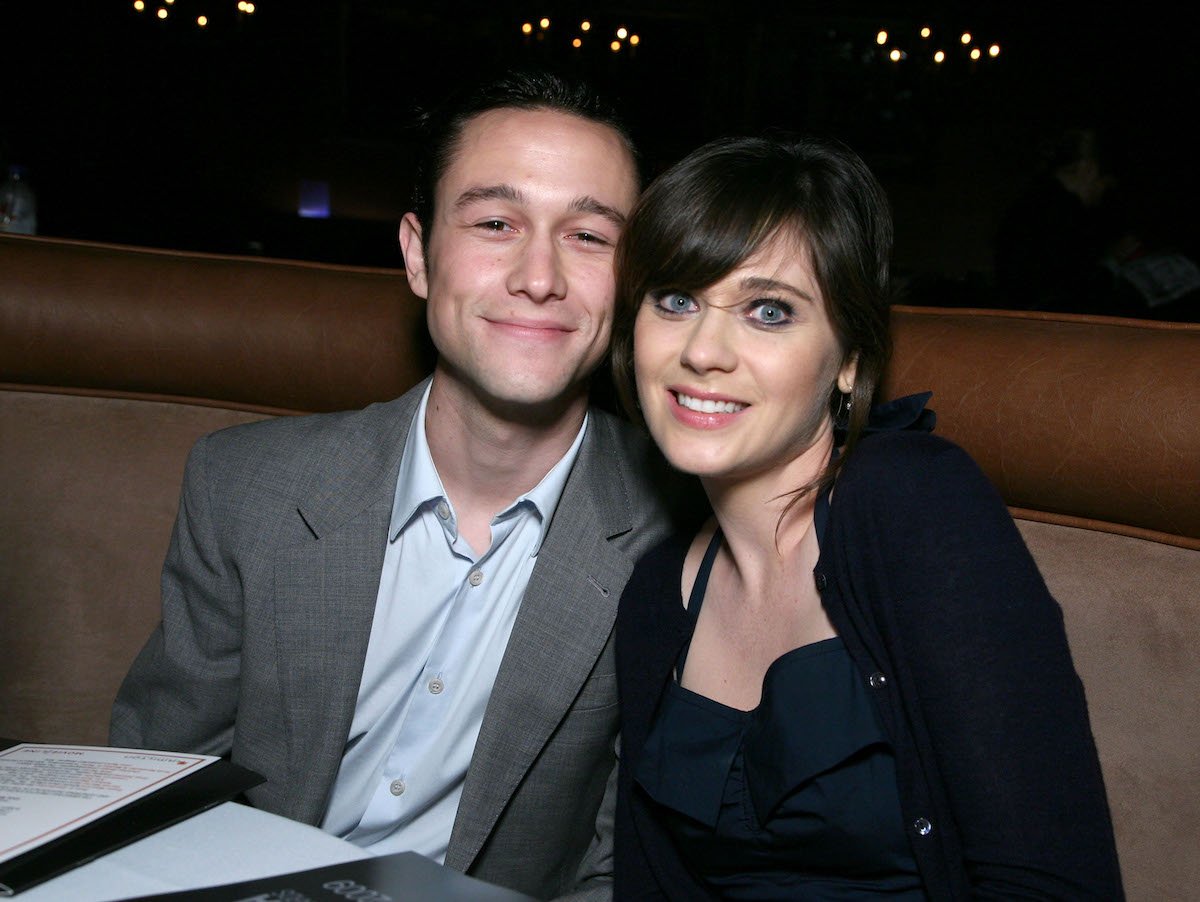 Actors Joseph Gordon-Levitt and Zooey Deschanel smile together at a media event in 2009