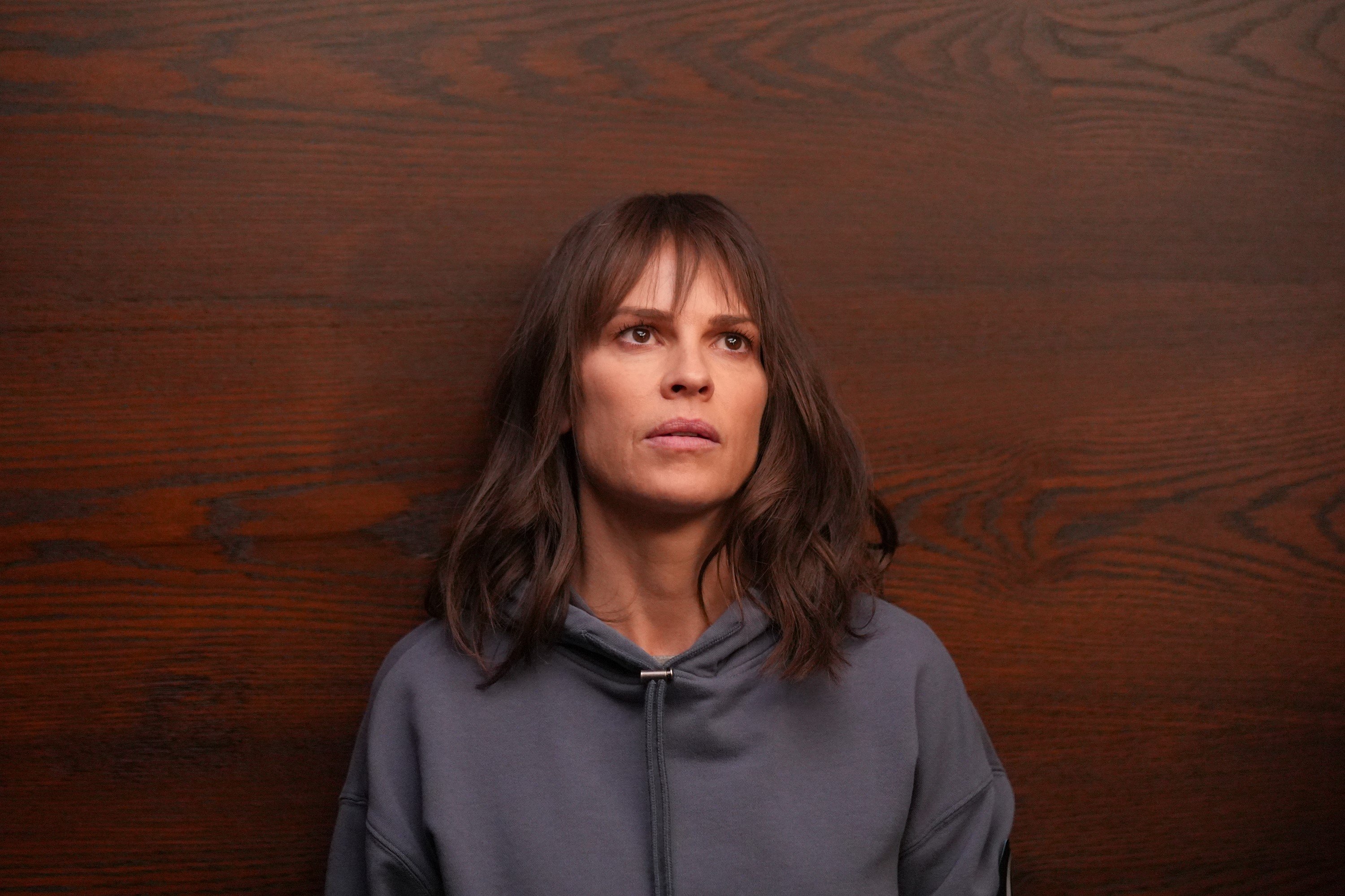 Hilary Swank, in character as Eileen Fitzgerald in 'Alaska Daily' on ABC, wears a light gray hoodie. In 'Alaska Daily,' the Concerned Citizen is threatening Eileen.
